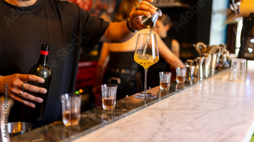 Obraz na płótnie Bartender preparing a premium cocktail with wine and spirits at an elegant bar c