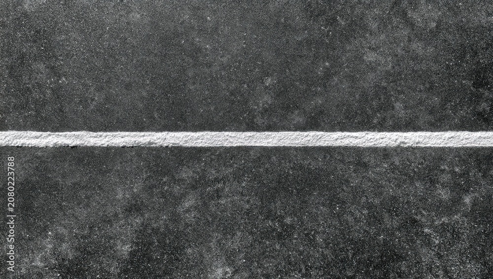 Fototapeta premium A stark white line bisects a dark, textured surface