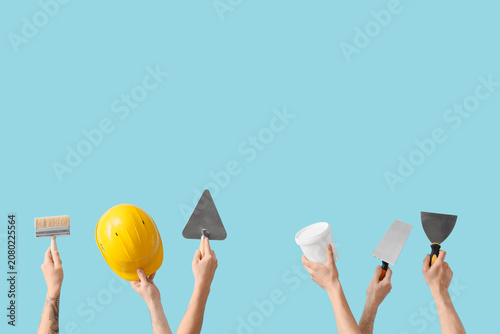 Foto Male hands with painters tools on blue background