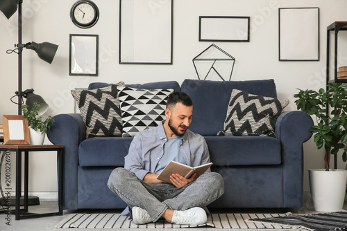 Young man reading book on f...