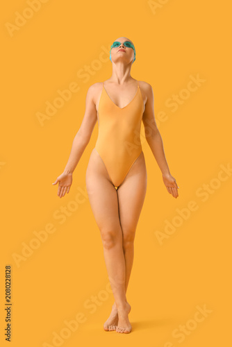 Female swimmer on yellow ba...