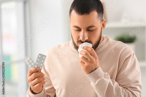 Sick young man with tissue ...