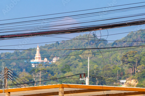 Thailand Temple on tropical hill mountain rainforest trees clouds blue sky.