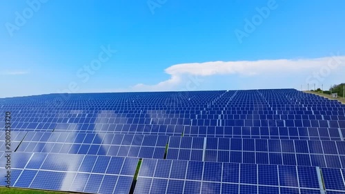 Large solar power farm panels generate renewable energy under blue sky