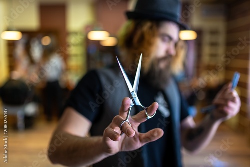 Close up of professional steel scissors held by hair stylist