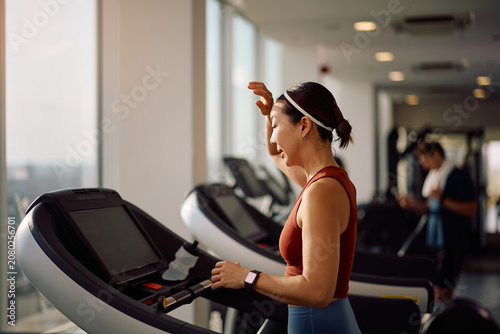 Obraz na płótnie Determined Korean sportswoman working out on treadmill in health club
