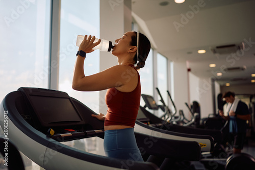 Photos Thirsty Korean sportswoman drinking water while working out in health club