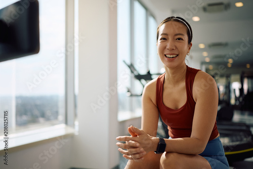 Tableau sur toile Happy Korean sportswoman exercising in gym and looking at camera.