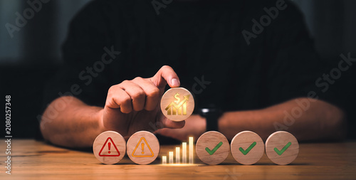 Hand placing wooden block with icon on a desk for business performance evaluation and assessment