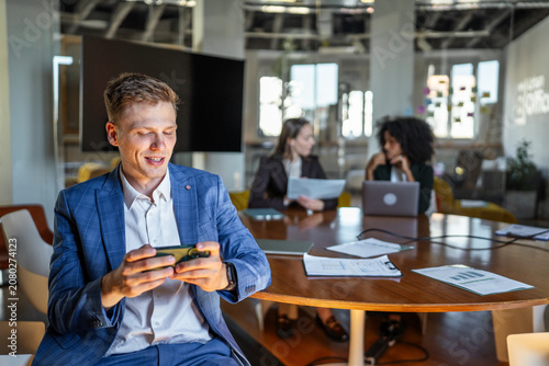 Canvastavla Businessman distracted by smart phone during office meeting