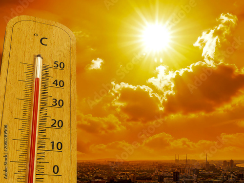 Thermometer showing extreme heat over a sun-drenched city landscape. Conceptual image representing global warming, rising temperatures, heatwave, and climate change effects.