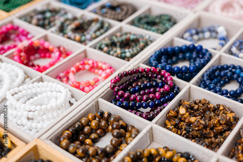 Handmade natural stone bracelets in various colors at market.