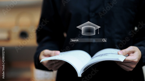 Bild auf Leinwand Student Holding Open Book with Graduation Cap and Search Bar, Online Course Sear
