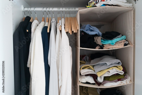 Foto Open White Closet with Hanging Clothes and Folded Garments in Fabric Organizer S