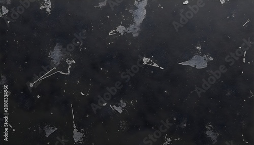 A dark background with scattered white fragments and spots is shown closely.
