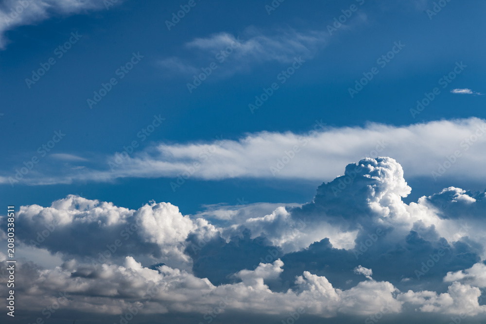 Fototapeta premium Dramáticos cúmulos de nubes de tormenta blancas contra un cielo azul profundo. Imponentes cúmulos de nubes de tormenta blancas sobre un cielo azul profundo; espectacular fondo meteorológico