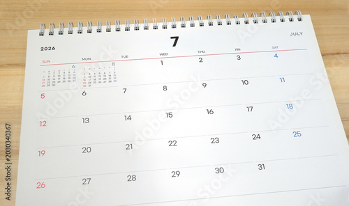 2026 calendar, July 2026 desk calendar placed on a wooden desk, 2026 New Year's resolutions.