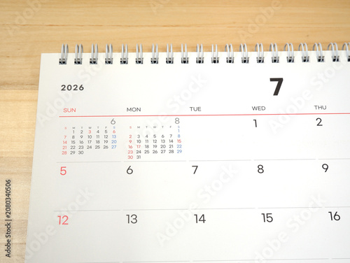 2026 calendar, July 2026 desk calendar placed on a wooden desk, 2026 New Year's resolutions.