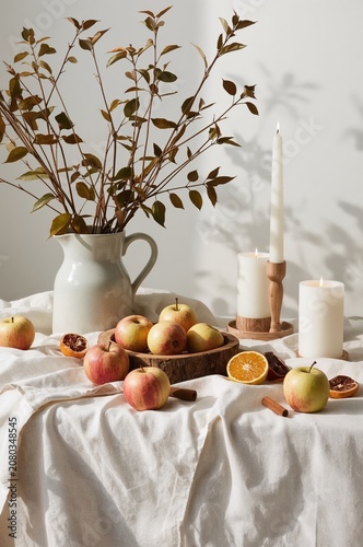 Autumn Decor With Apples, Candles, and Leaves on a Table in a Bright Room