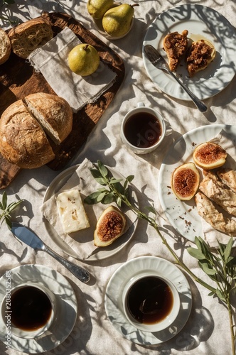 Delicious Breakfast Spread With Bread, Figs, Pears, and Coffee on a Table