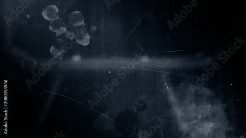 Abstract dark background featuring a dusty glass surface with visible fingerprint smudges and fine scratches in low light