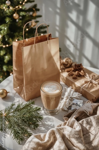Coffee Cup and Gift Bag on a Table Near a Christmas Tree During the Holiday S...