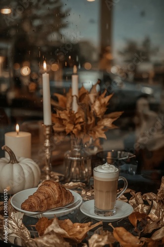 Warm Drinks and Baked Goods on a Table Near a Window in a Cafe During Early E...