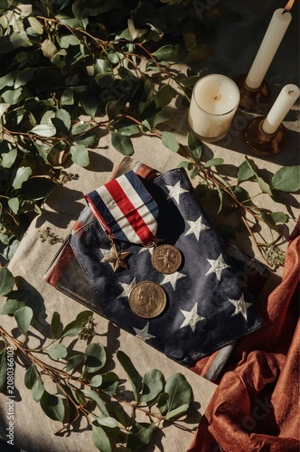 Military Medals and Flag Displayed on a Table With Candles and Greenery