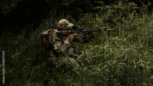 Bild auf Leinwand Camouflaged soldier in the middle of wilderness on a recon mission