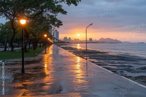 Scenic sunset on a rain-slicked coastal promenade.