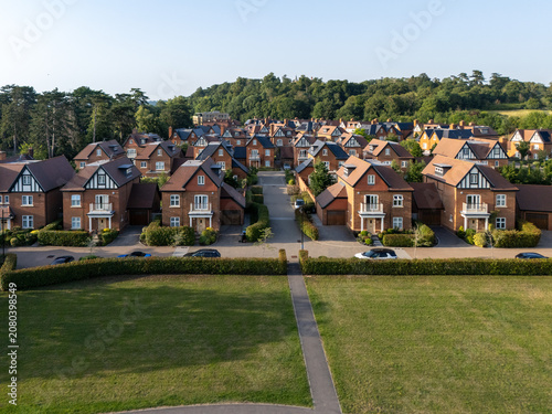 Aerial view of luxury new build homes featuring brick facades and tiled roofs, surrounded by manicured hedges and green lawns in Maidenhead, England, United Kingdom.