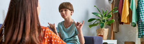 Valokuva A mother enjoys a heartwarming conversation with her son using sign language