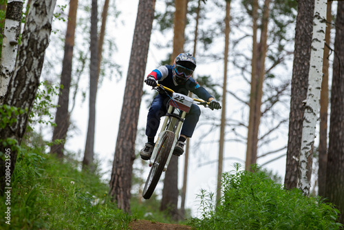 Athlete racer jumped over hill during downhill competition