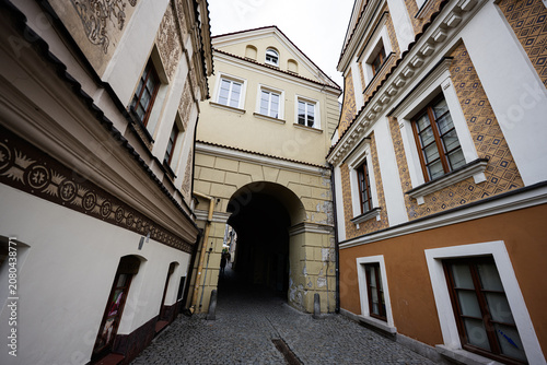 фотографія Historic narrow archway and cobblestone street in Lublin Poland with decorated f