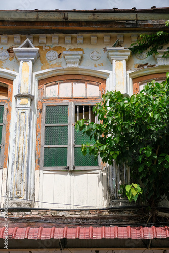 Historic colonial shophouse window with weathered facade in George Town Penang Malaysia.