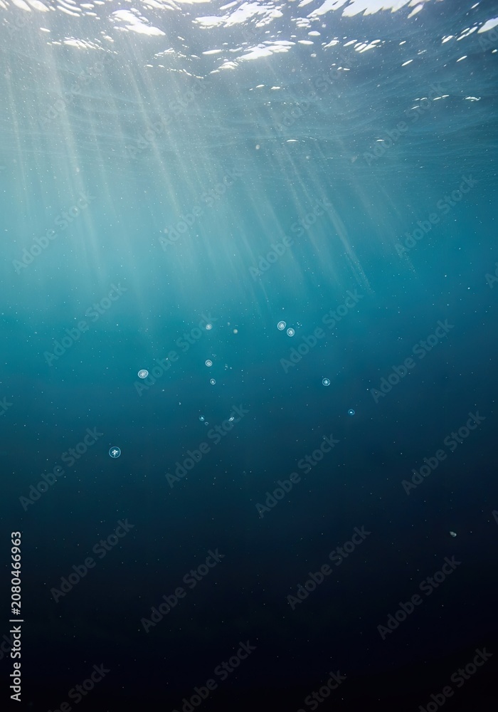 Obraz premium Abstract underwater blue background with light and particles