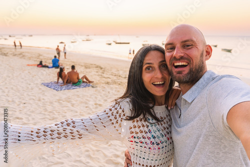Valokuva Happy couple taking beach selfie during sunset, Zanzibar Tanzania, Indian Ocean