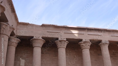 A view of the historic stone columns and carved hieroglyphics in the courtyard of the Temple of Edfu, an ancient Egyptian landmark in Edfu, Egypt.