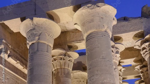 Night view of the ancient stone columns at the Kom Ombo Temple in Aswan, Egypt, featuring detailed hieroglyphics and architectural carvings.