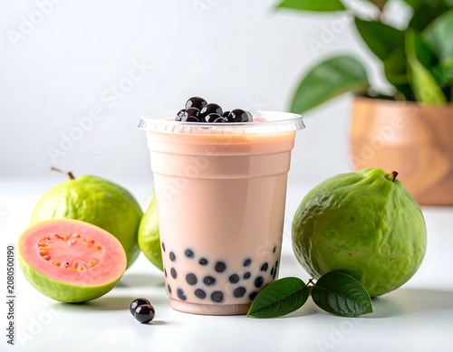 Bubble tea with fresh guava and leaves on white table.