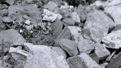 Fotografie Black and white construction debris pile with crushed fragments, dirt particles, and gritty raw surface