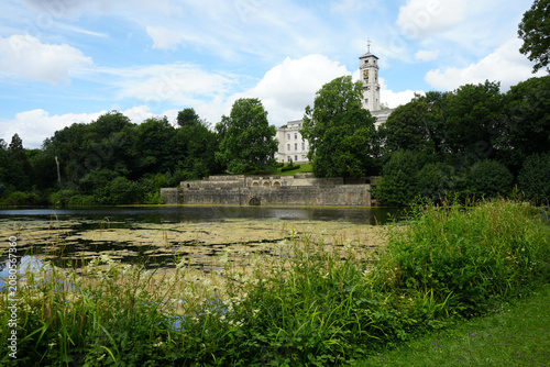 Scenic View Of The Historic Trent Building With Its Iconic Clock Tower Overlooking The Tranquil Lake And Lush Greenery In Highfields Park, Nottingham, England.