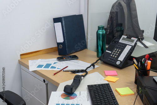 Fotografi Busy office desk with telephone, charts, and stationery