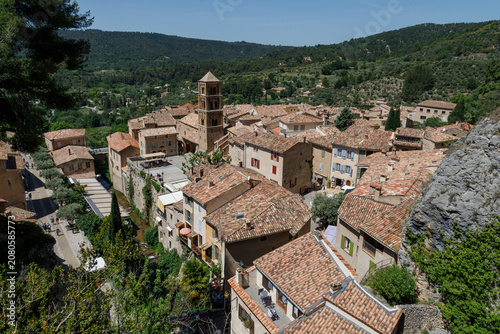 High angle view of Moustiers-Sainte-Marie village with traditional stone houses and church tower, Provence, France.