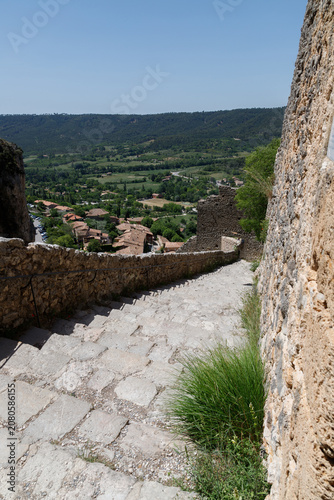 Ancient Stone Stairway Descending to a Medieval Village with Scenic Countryside View.