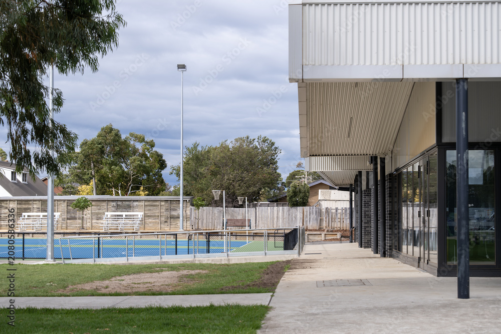 Obraz premium Modern community sports centre building beside outdoor courts in Hoppers Crossing Melbourne Australia. Suburban council recreation facility. Concept of wellbeing infrastructure
