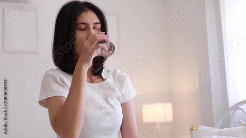 A woman waking up and drinking plain water for good health in the morning. A health-conscious idea.