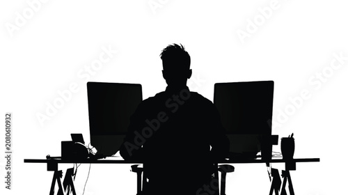 Employee works on two computer screens while sitting in a bright office environment.