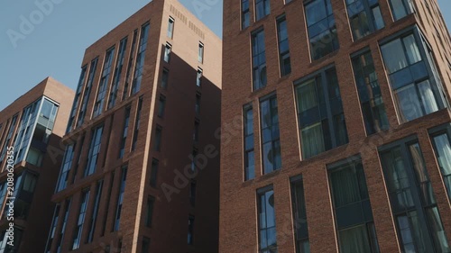 Bottom view of a modern brick building with mirrored windows