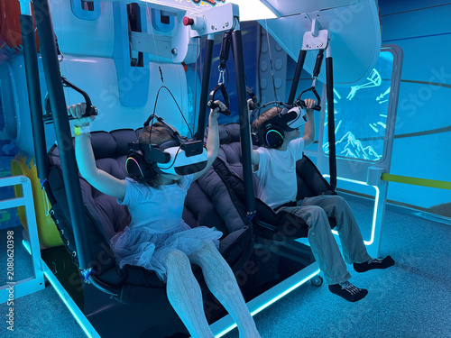 Kids enjoying virtual reality simulator attraction in entertainment center